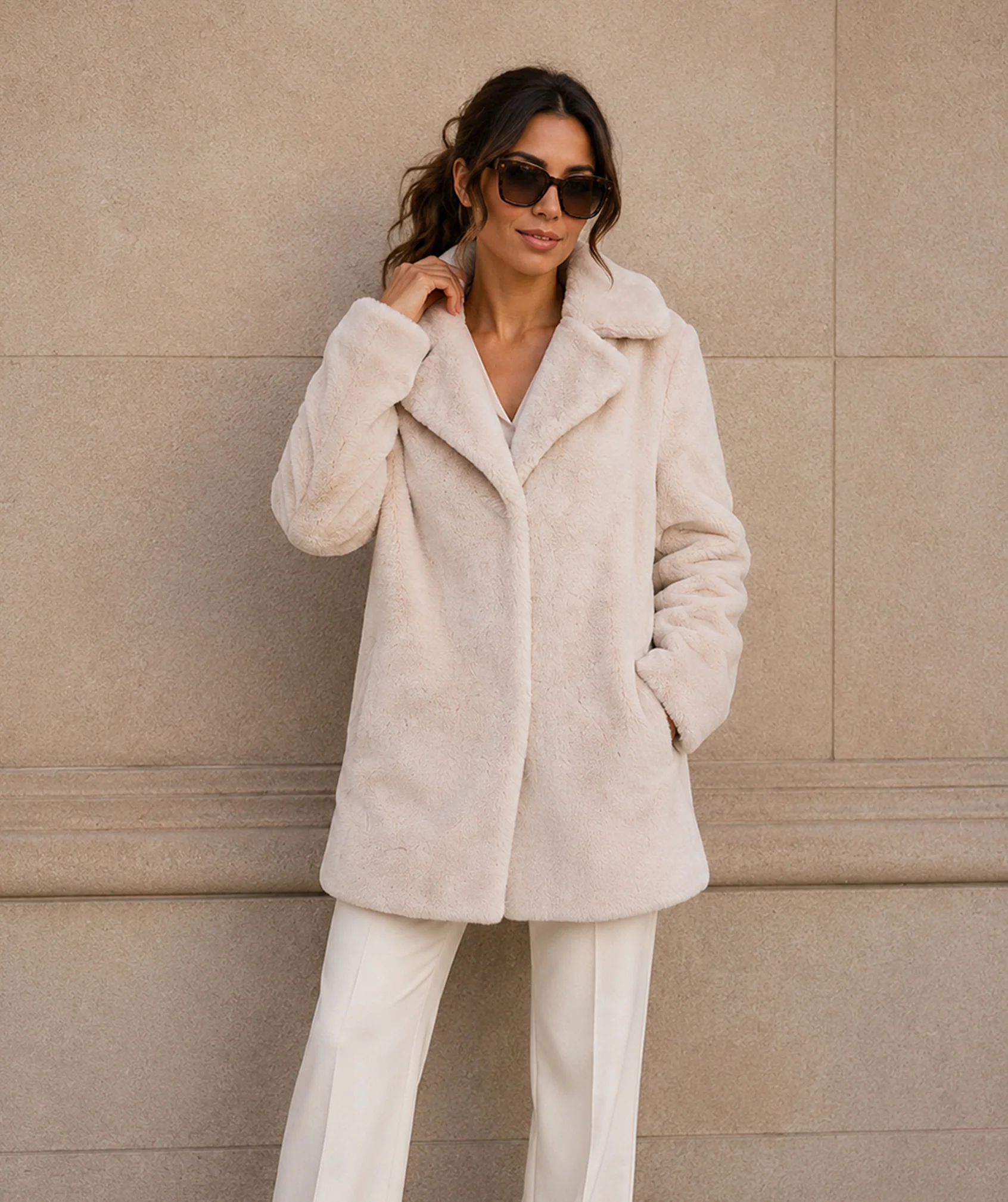 KennedyCoat_Pearl Woman wearing the Kennedy plush faux fur coat in pearl over white trousers, front view