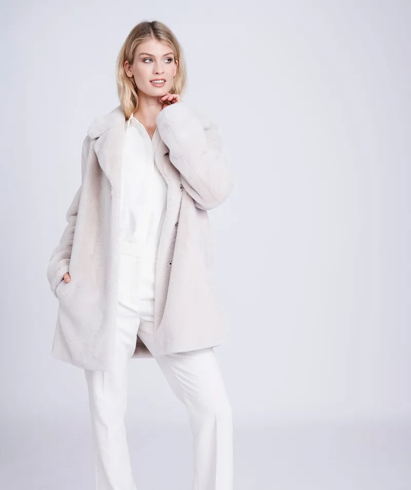 kennedy plush faux fur coat in pearl Woman wearing the Kennedy plush faux fur coat in pearl over white trousers, front view